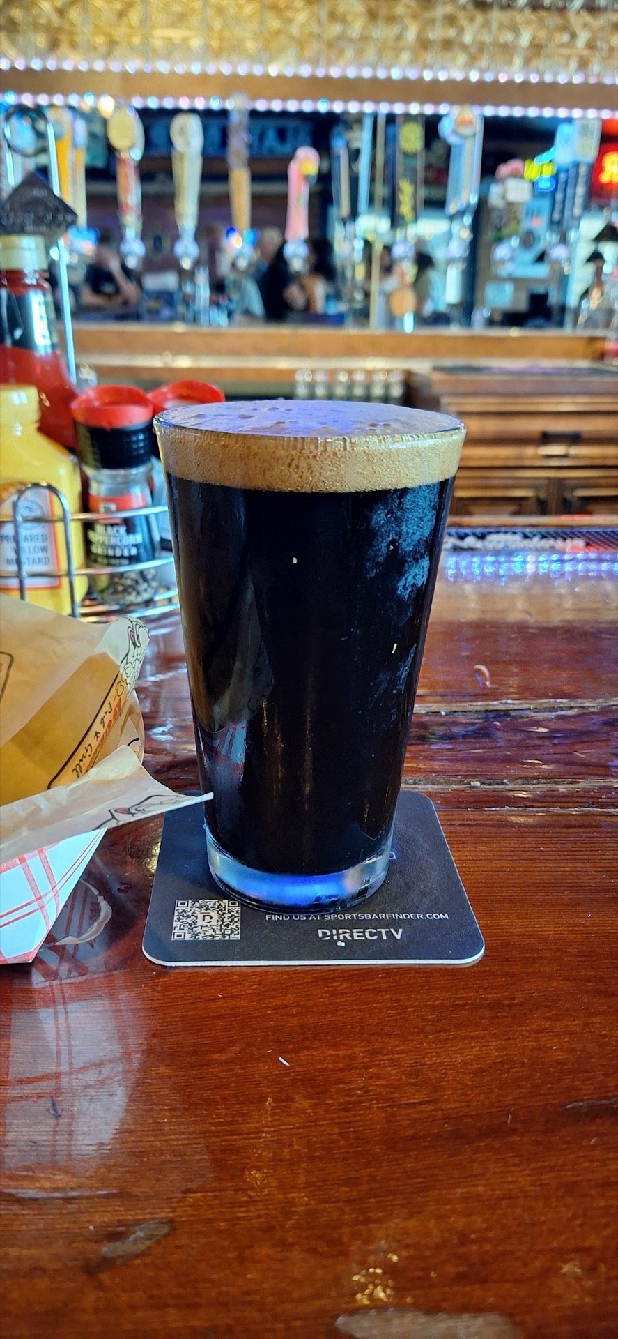 A pint of stout in front of the tap handles